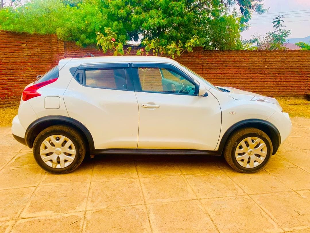 The white Nissan Juke photographed side-on against a brick wall