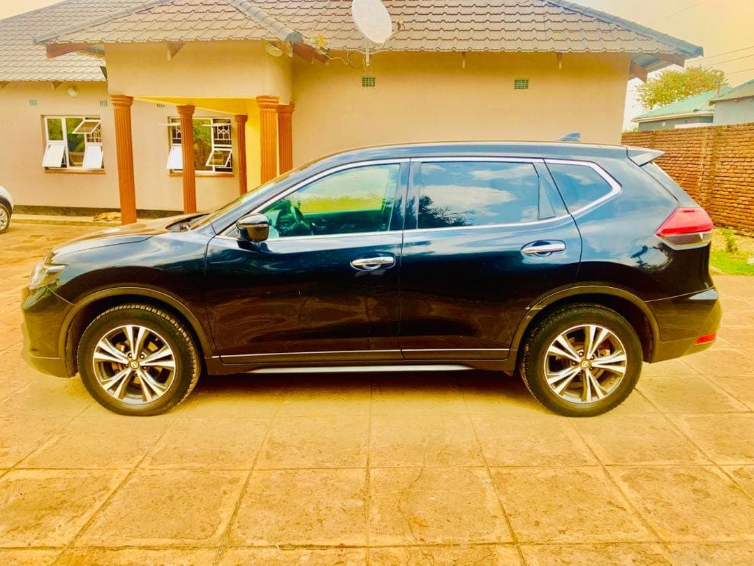 The black Nissan X-Trail, side-on
